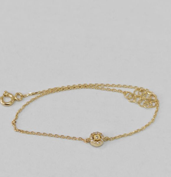 Narukvica od žutog zlata sa motivom cveta i cirkonima, prikazana položeno na svetloj podlozi, sa detaljno vidljivim lancem i ukrasom.