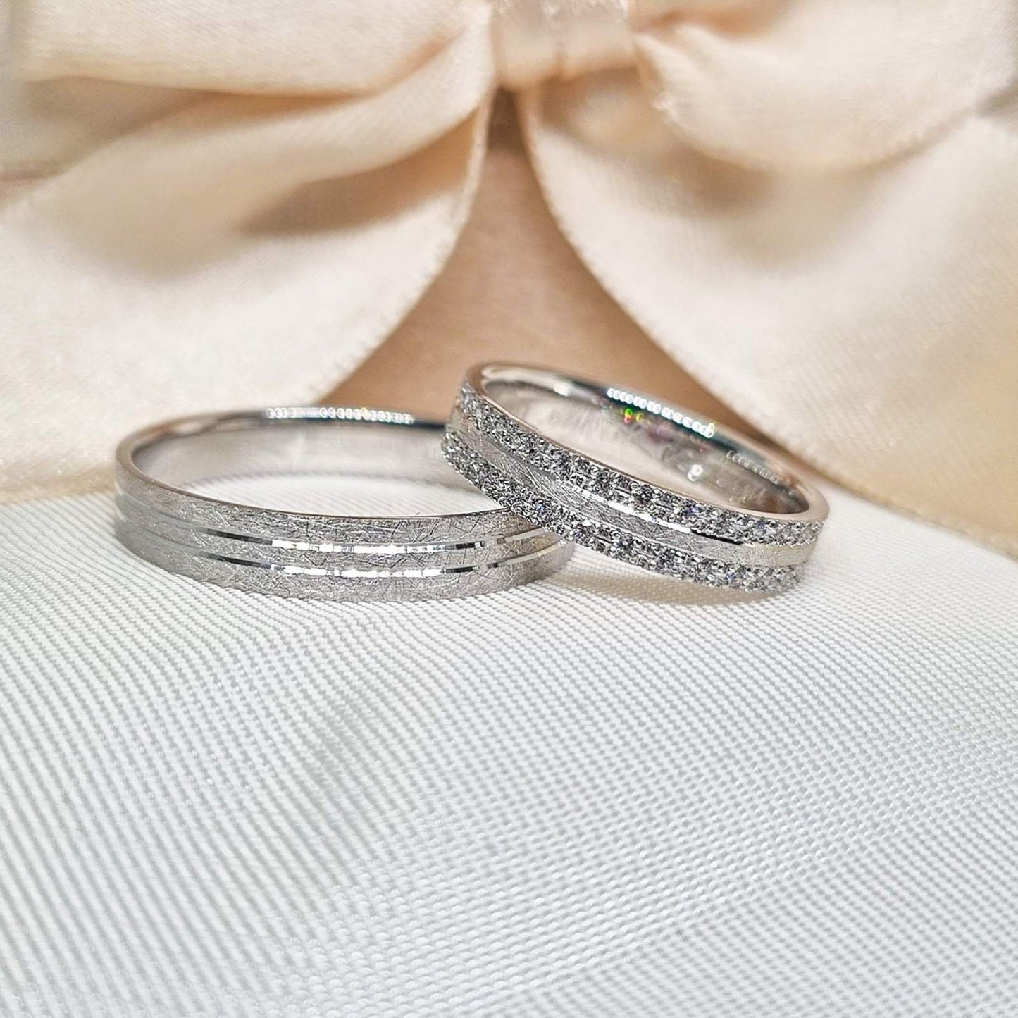 Burme belo zlato - sjaj sa cirkonima, fotografisane na beloj podlozi, sa krem mašnom u pozadini