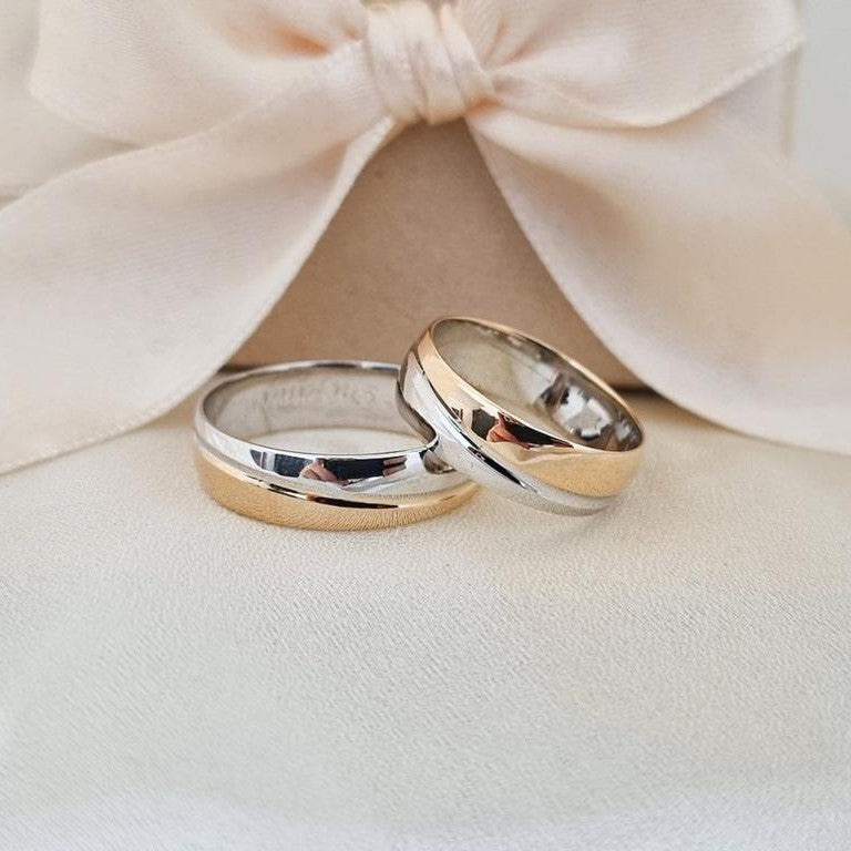 Burme belo žuto zlato sa kosom linijom, postavljene na bež tkanini sa svetlom pozadinom.