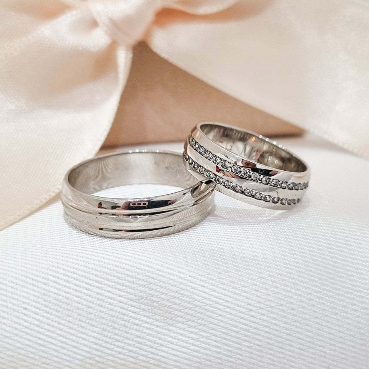 Par burmi od belog zlata na beloj tkanini – muška burma sa mat i sjajnim efektom, ženska sa duplim redom sitnih cirkona.