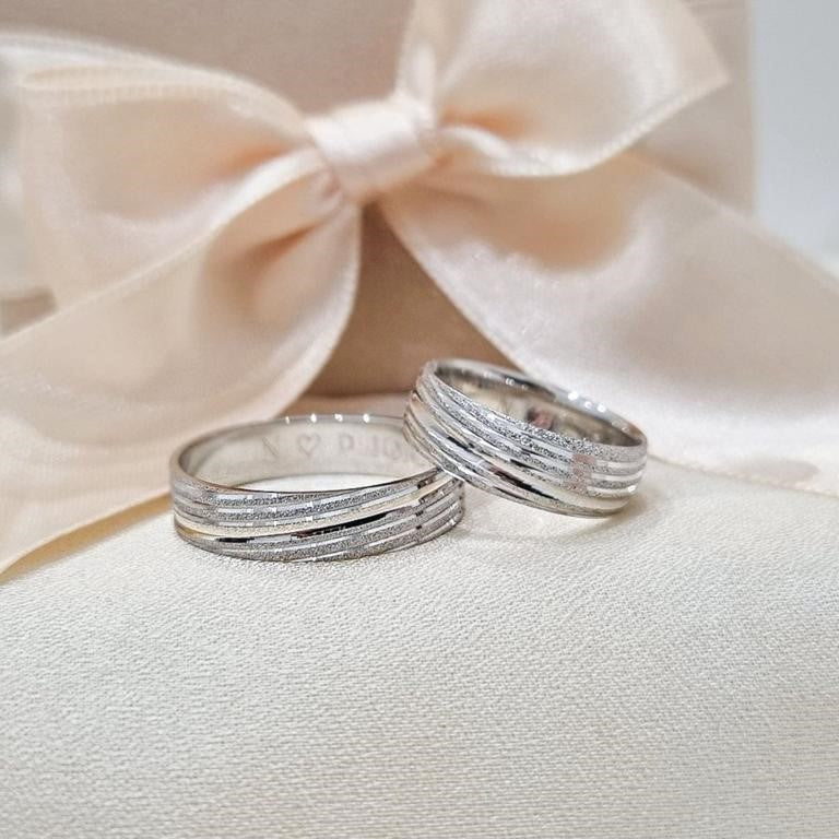 Zlatne burme sa više delikatnih linija, kombinacija matiranih i poliranih detalja, postavljene na bež tkanini sa svetlom pozadinom.