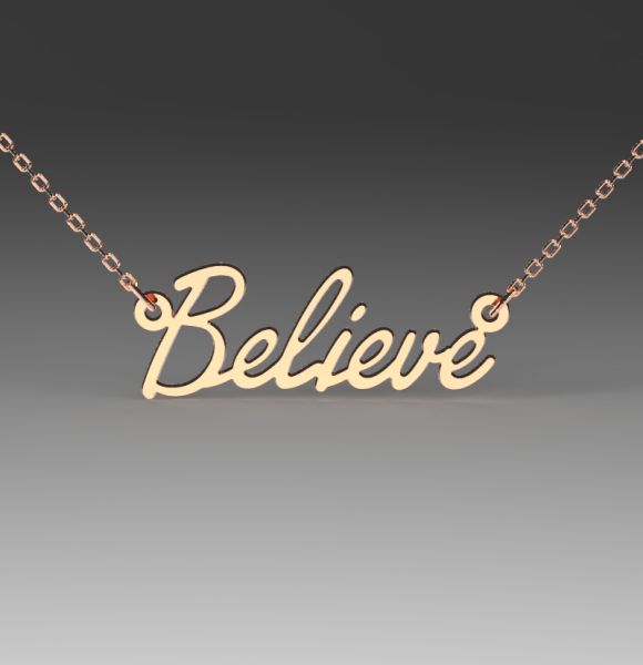 Slika prikazuje zlatnu ogrlicu sa priveskom u obliku reči "Believe" napisanom elegantnim kurzivnim fontom.
