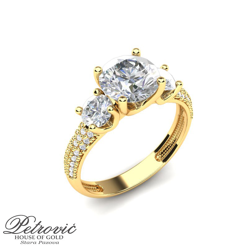 Verenički prsten od žutog zlata sa tri dominantna okrugla cirkona, pri čemu je središnji kamen najveći, uz niz sitnih cirkona duž obruča, prikazan iz ukoso-gornjeg ugla na beloj pozadini.