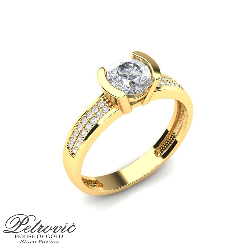 Verenički prsten izrađen od žutog zlata sa velikim centralnim okruglim cirkonom učvršćenim masivnim bočnim drškama, dodatno ukrašen nizom sitnih cirkona duž ramena, prikazan iz perspektive na beloj pozadini.