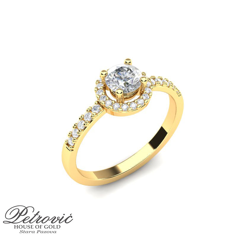 Verenički prsten izrađen od žutog zlata sa centralnim okruglim kamenom, okružen manjim cirkonima prikazan iz ugla na beloj pozadini.