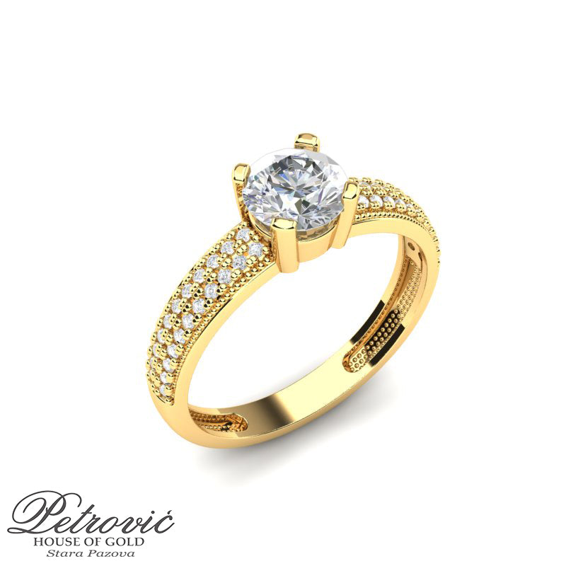 Verenički prsten izrađen od žutog zlata sa dominantnim okruglim dijamantom u sredini i dvostrukim nizom sitnih brilijanata duž obruča, prikazan na beloj pozadini iz bočnog ugla.