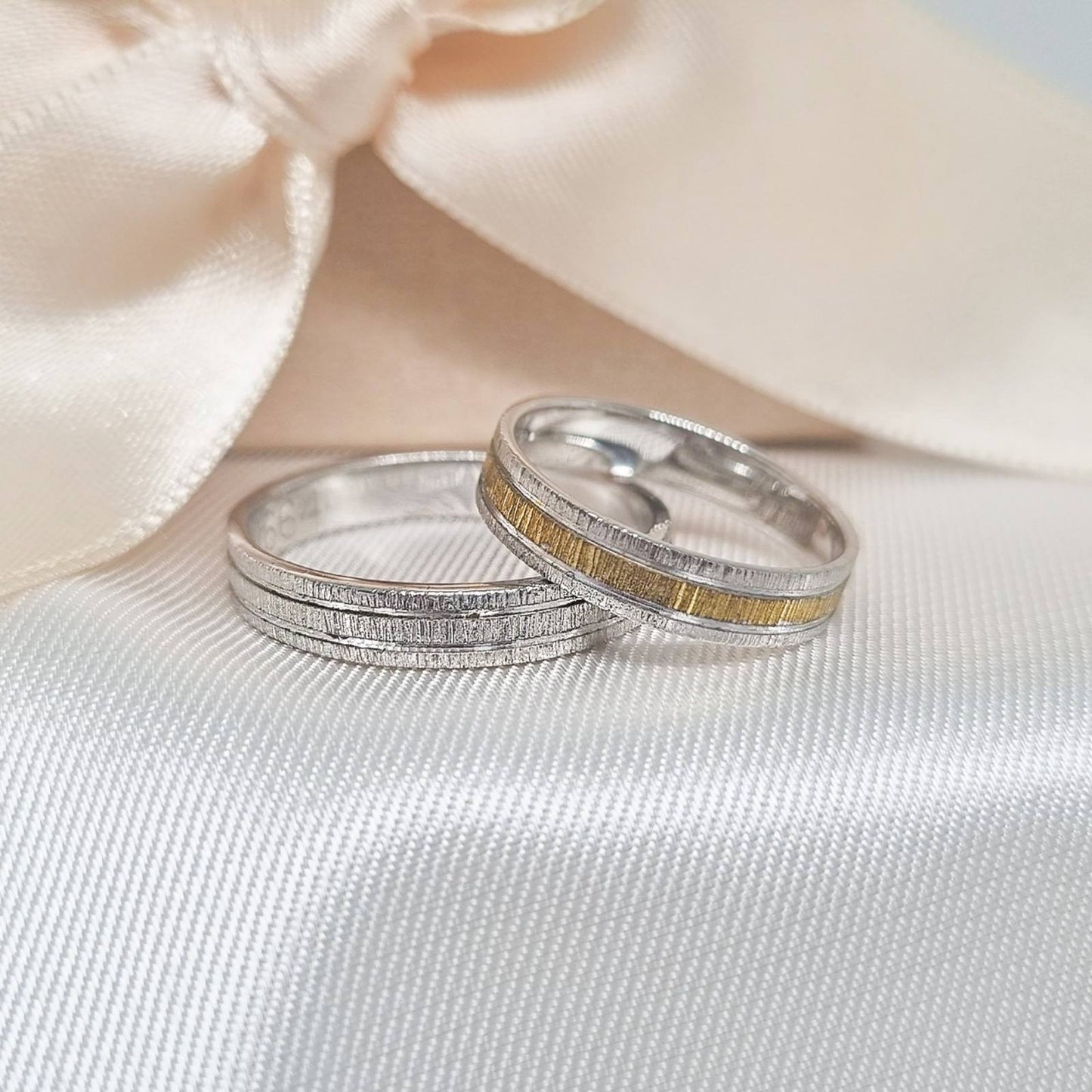 Par burmi od belog zlata sa matiranim i graviranim linijama, muška burma u potpunosti od belog zlata, a ženska sa detaljem od žutog zlata.