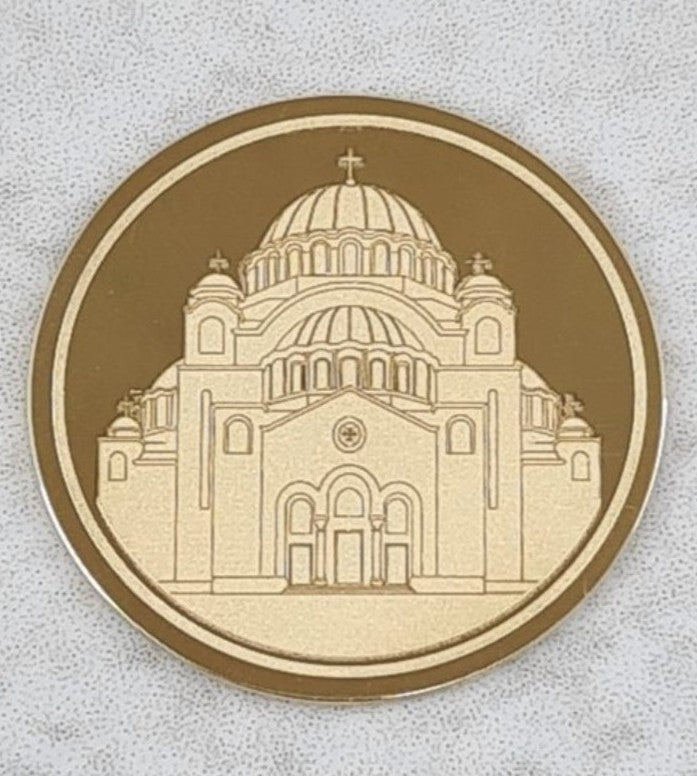 Zlatnik sa detaljno ugraviranim prikazom Hrama Svetog Save, simetrično prikazanog na glatkoj zlatnoj površini, bez natpisa ili dodatnih elemenata.